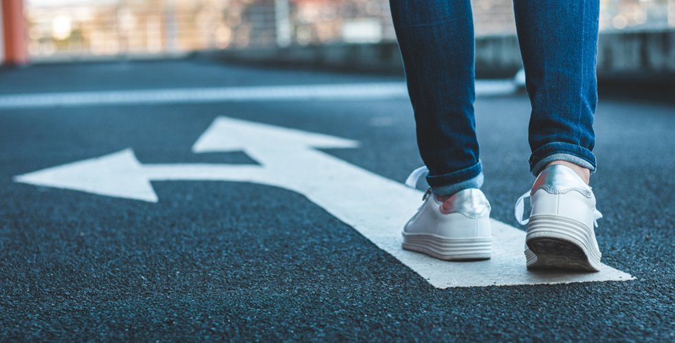 Woman walking with an arrow on the ground