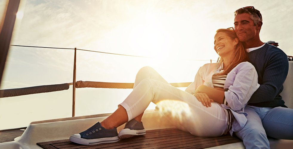 Couple laying together on boat with sunset